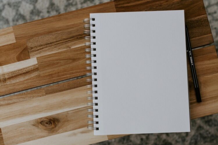Quaderno e calcolatrice su un tavolo: quanto si guadagna con le pulizie